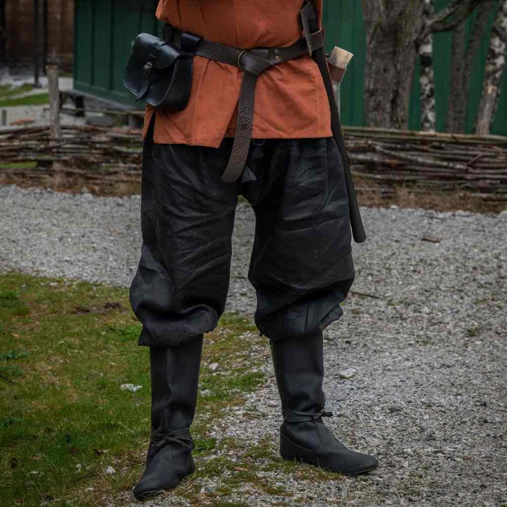 Black linen Pirate pants with tapered legs and lace-up closures, worn with boots and an orange tunic.