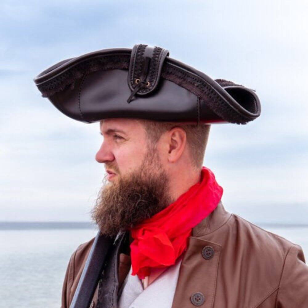 Man wearing a dark brown faux leather Pirate tricorn hat with canvas laced trim.