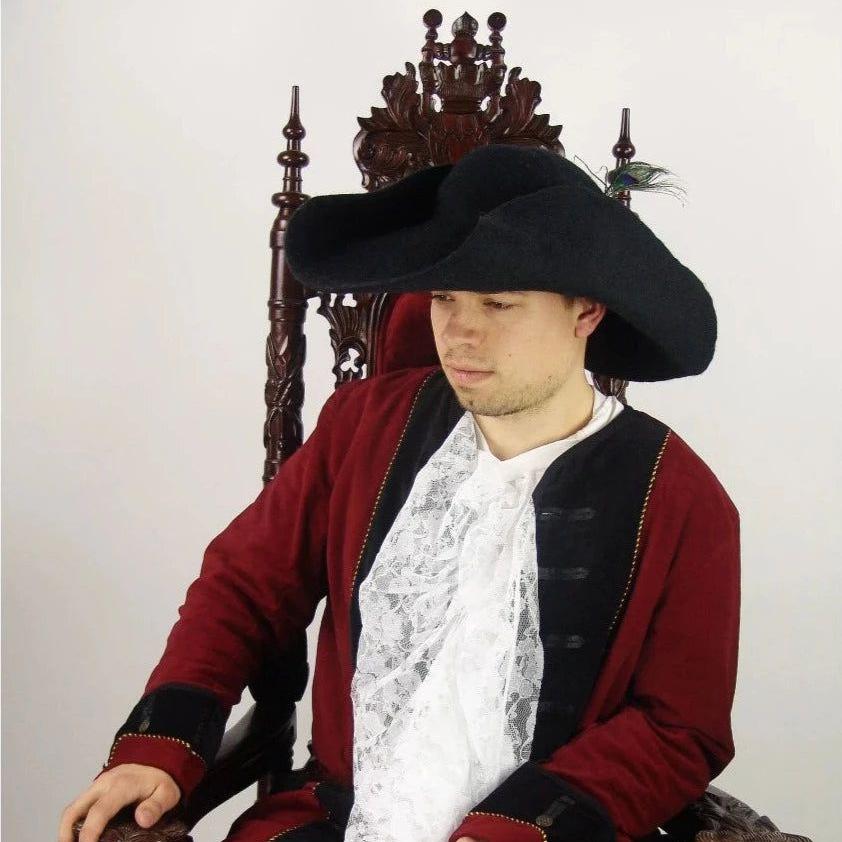 Black felted wool Pirate hat with a cocked brim and feather, worn by a man in a red jacket.