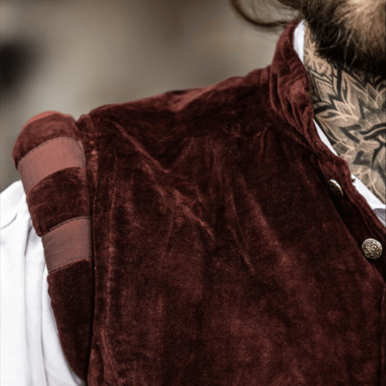 Dark red velvet Pirate vest with puffed shoulders and metal buttons, worn over a white shirt.