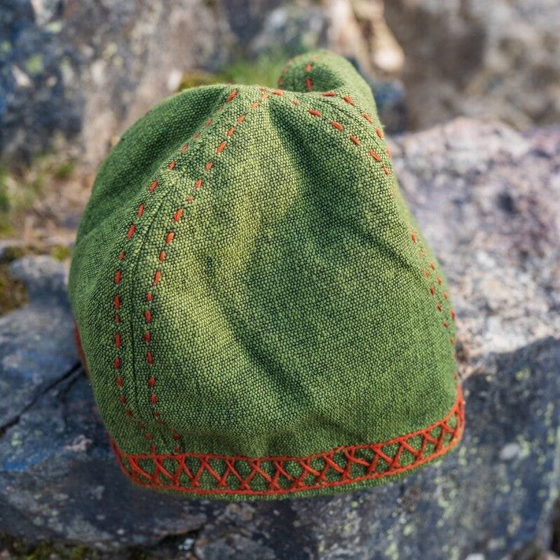 Green Pirate Wool Cap with distinctive Anders embroidery, a beanie-style hat on a rock.