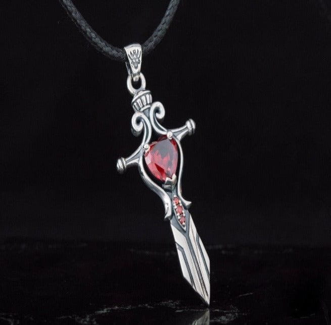 Handcrafted sterling silver Pirate sword pendant with a large red cubic zirconia and smaller red accents on a black cord.