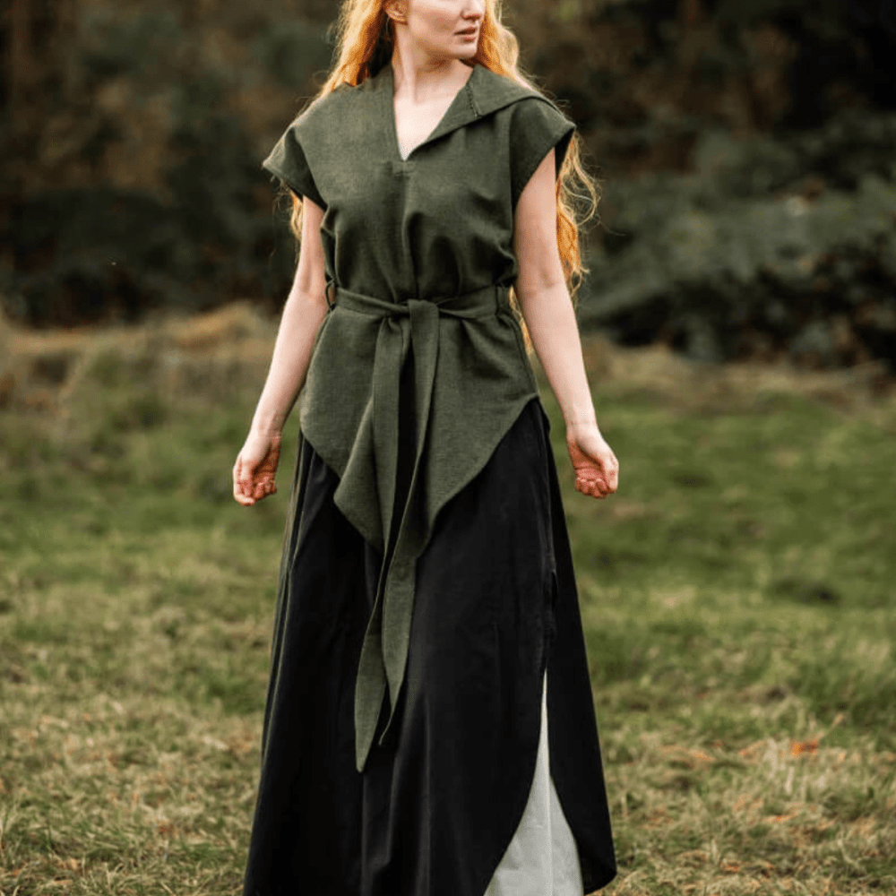 Pirate-style green hooded cotton tunic with belt, worn over a black skirt, in a grassy outdoor setting.