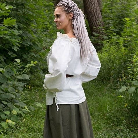 Woman in a loose white cotton Pirate shirt with adjustable drawstrings at the neckline and wrists.