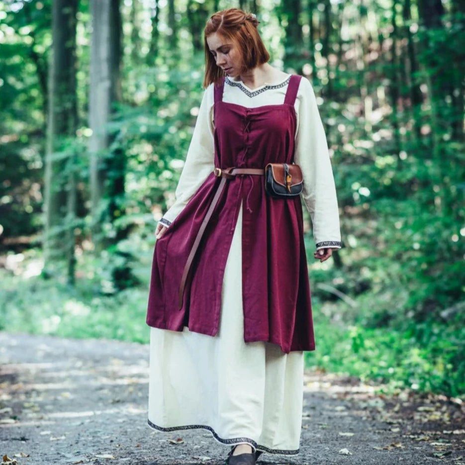 Brown leather Pirate belt with brass-coated buckle worn over a burgundy and cream dress.