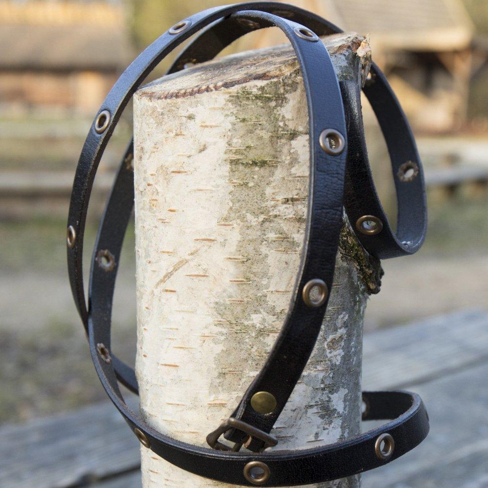 Black multistrap genuine leather Pirate bracelet with brass hardware and adjustable closure, wrapped around a tree stump.