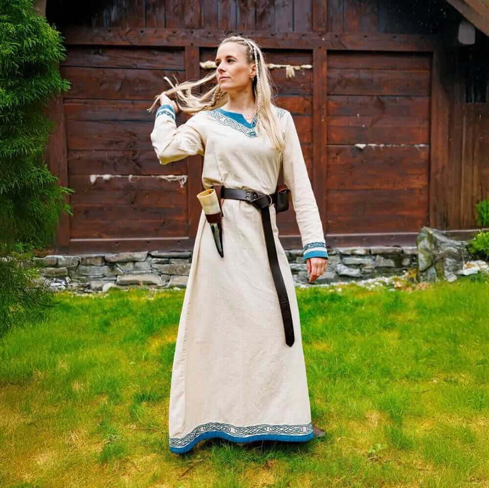 Natural cotton Pirate gown with blue trim, A-line silhouette, worn by a woman outdoors.