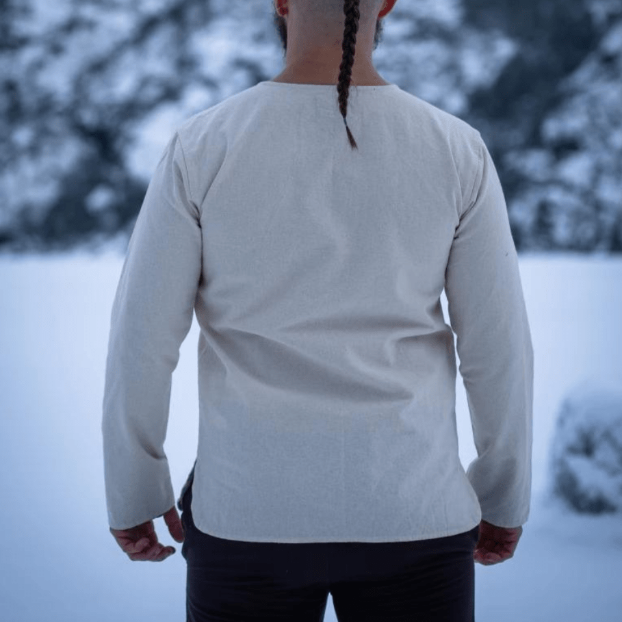 Natural cotton long-sleeve Pirate tunic in a light, neutral color, shown from the back in a snowy setting.