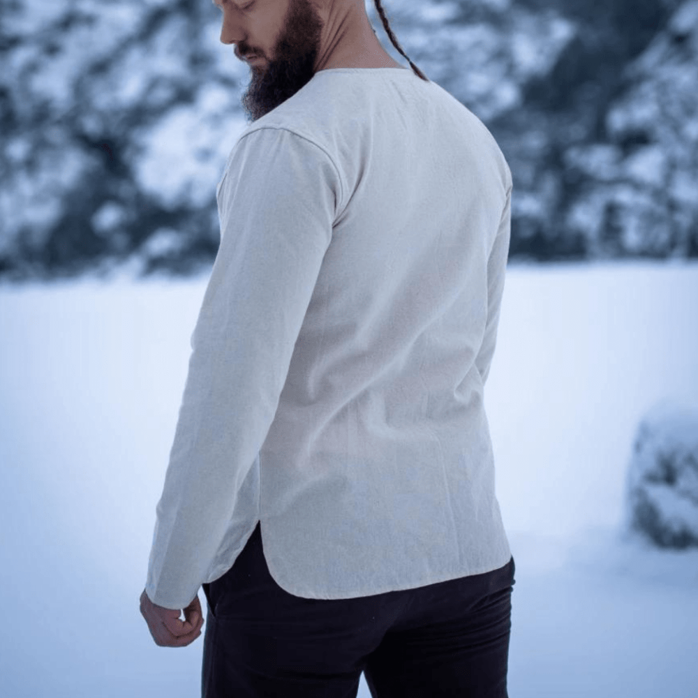 Natural cotton long-sleeve Pirate tunic with lace-up collar, worn by a man in a snowy setting.