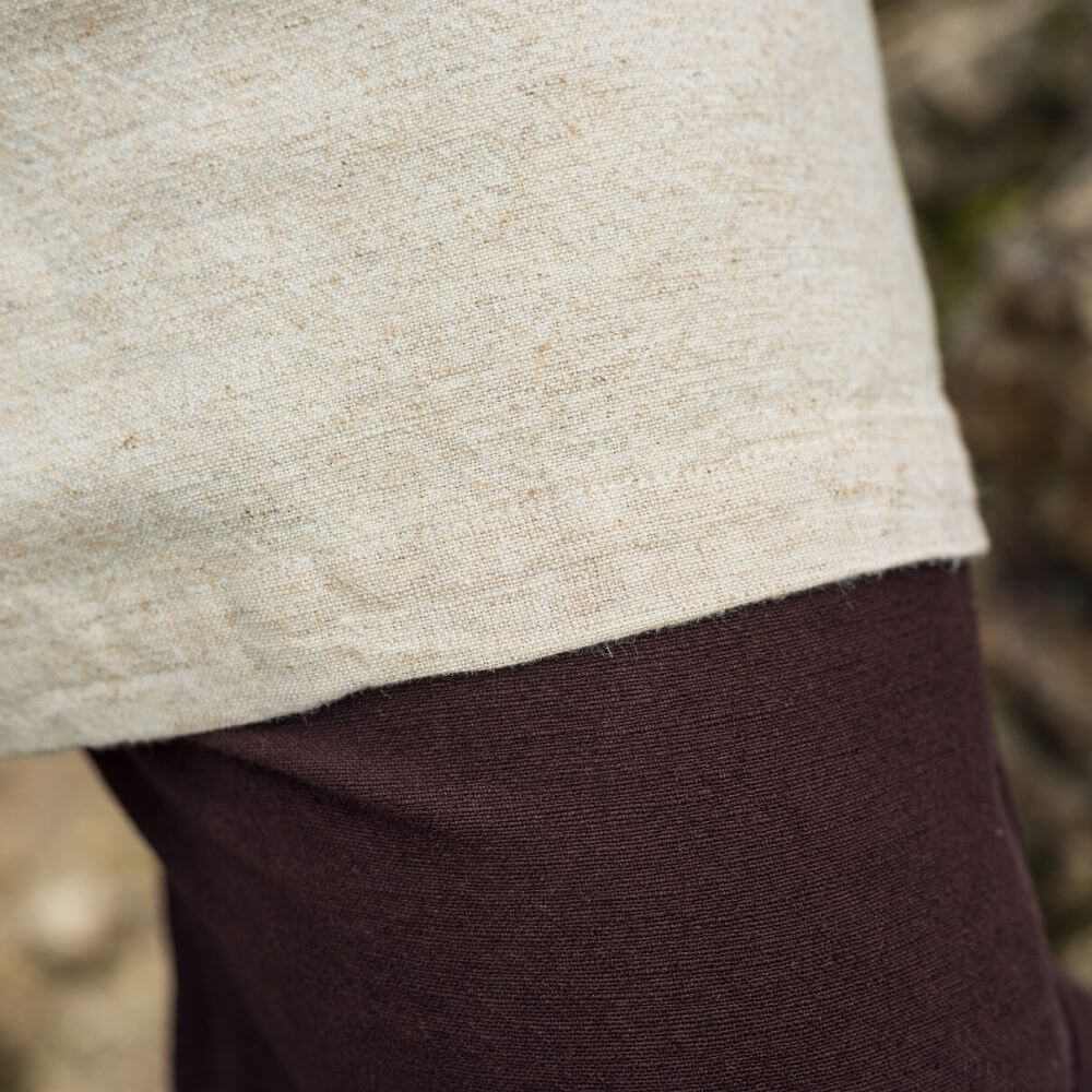 Natural linen pirate tunic, thigh-length, with a classic cut neckline over dark pants.