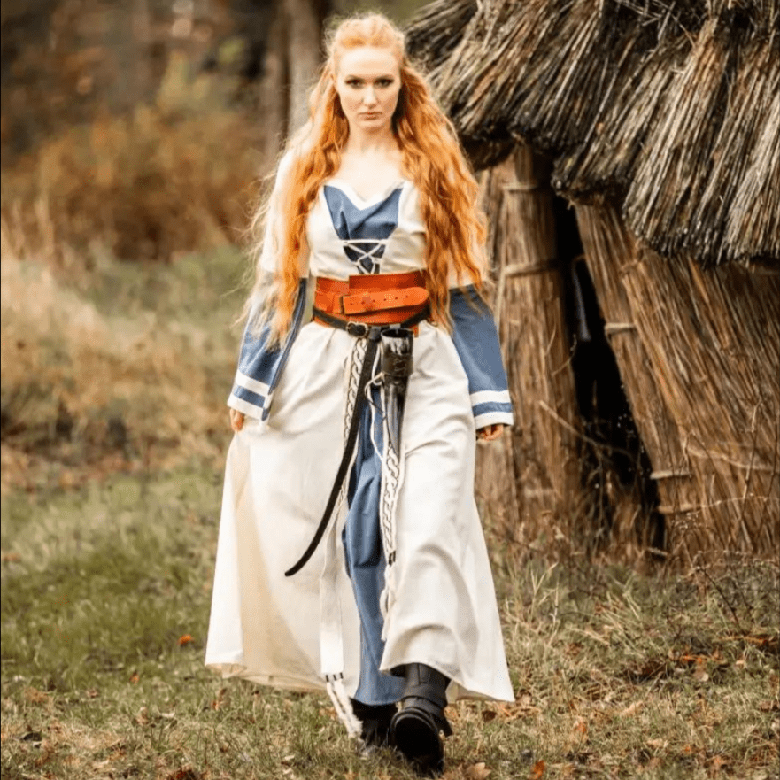 Natural and blue cotton long-sleeve Pirate dress with laced front, worn by a woman in a forest setting.