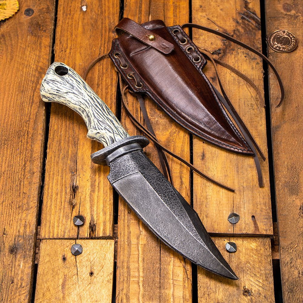 Pirate LARP foam combat knife with faux bone handle and a brown leather scabbard on a wooden surface.