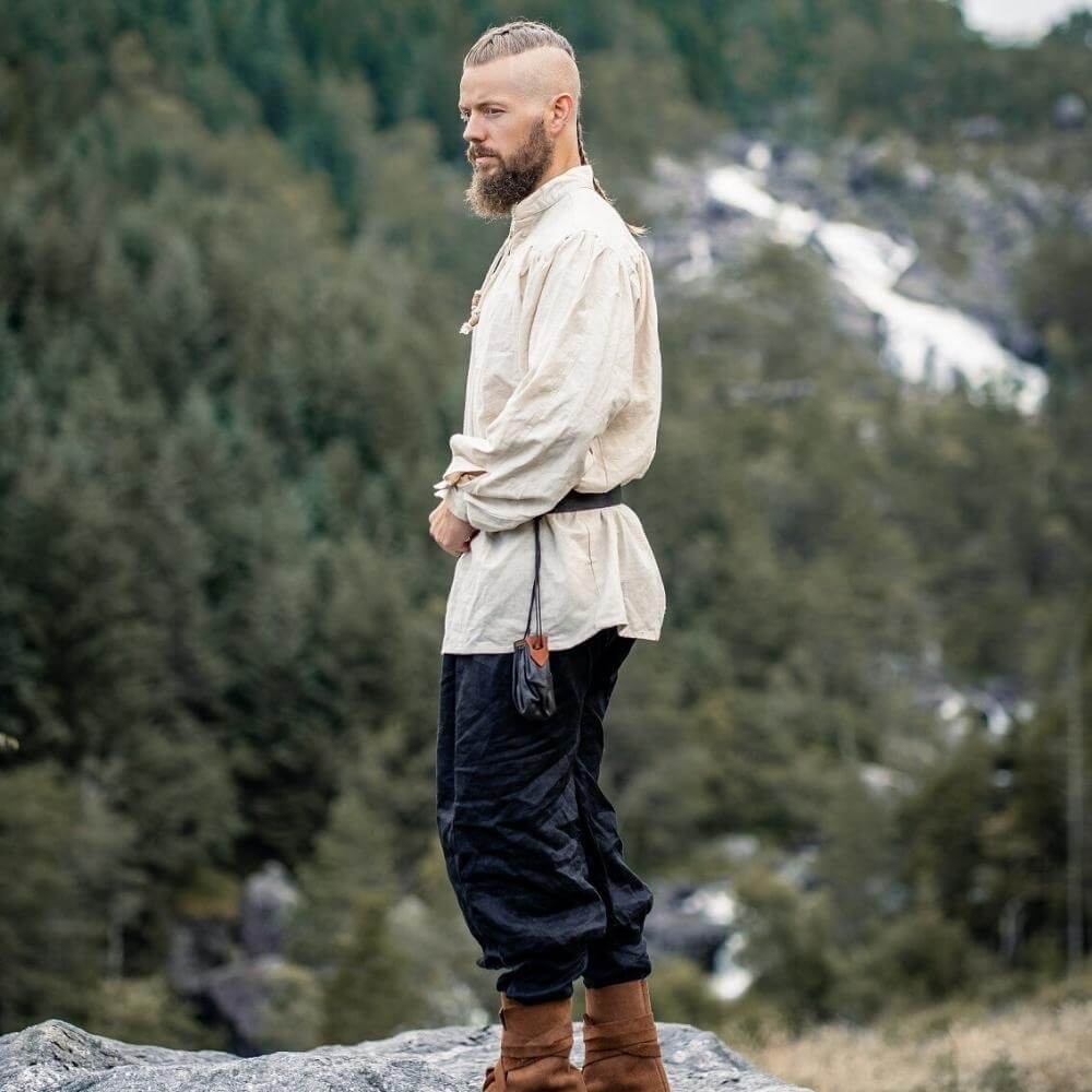 Pirate shirt in natural white, lace-up collar, worn by a man with a beard, outdoors.