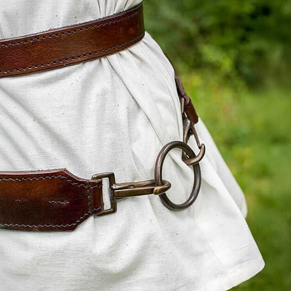 Pirate brown leather sword belt with brass buckles and ring, worn over a white tunic.