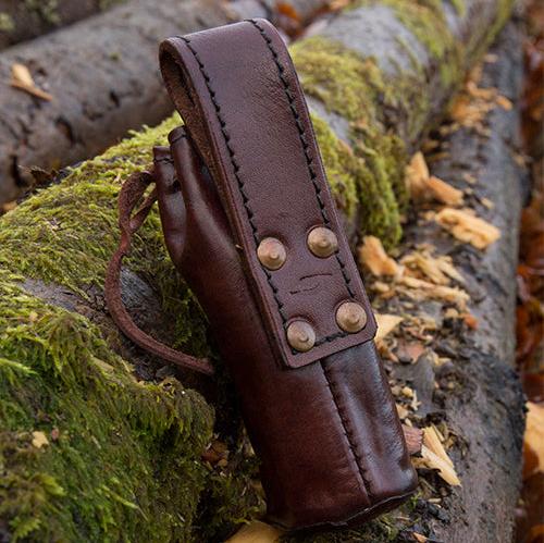 Pirate brass telescope in a dark brown genuine leather belt pouch, resting on mossy logs.