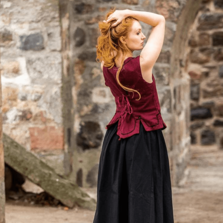 Red cotton Pirate wench bodice with back lacing and embroidery, worn by a woman with red hair.
