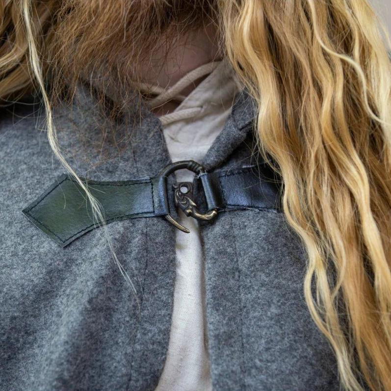 Close-up of a gray wool Pirate cloak with a detailed metal wolf clasp closure.