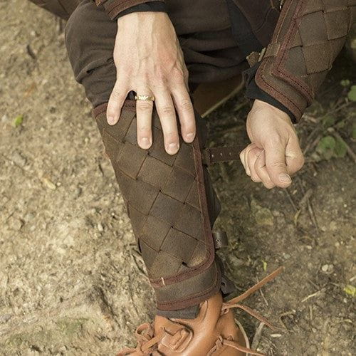 Brown woven leather Pirate greaves with brass buckles, worn on a leg over boots.