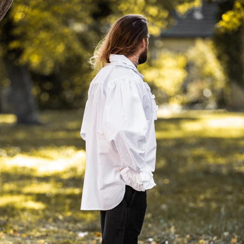 White cotton Pirate shirt with ruffles, puffed sleeves, and wooden buttons on a person outdoors.