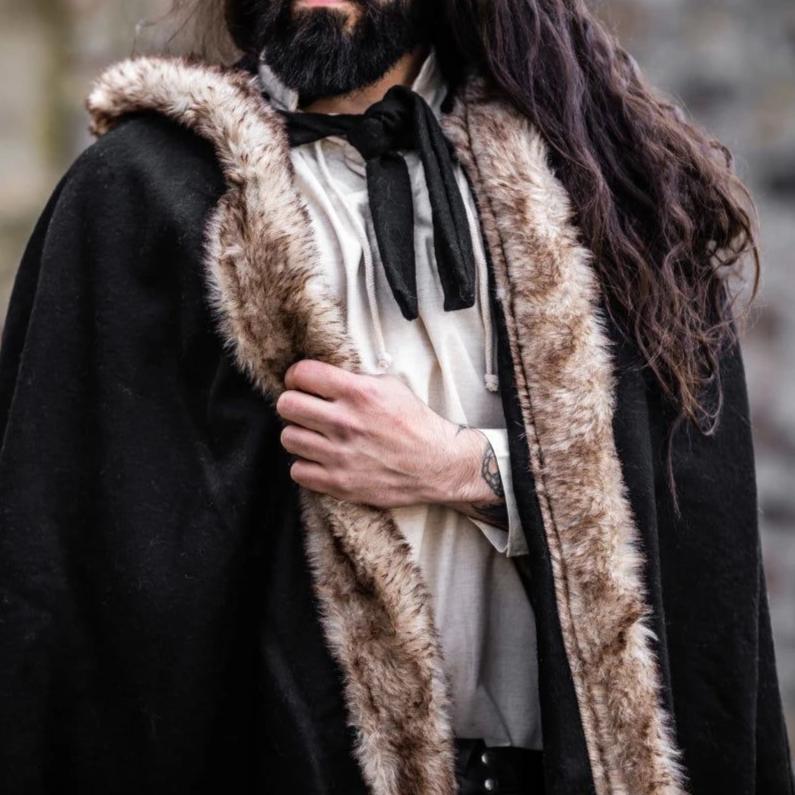 Black hooded Pirate cape made of heavyweight wool with luxurious faux fur trim, worn by a man.
