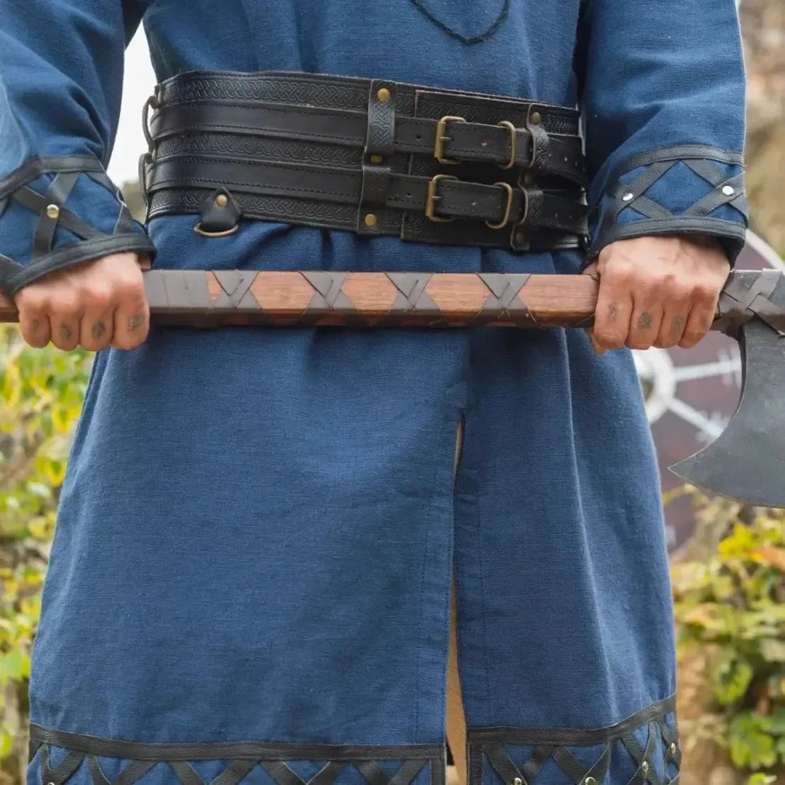 Black thick leather Pirate double belt with brass buckles over a blue tunic, held by a person with an axe.