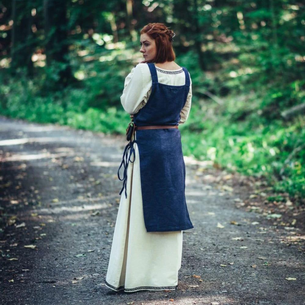 Blue cotton Pirate overdress with wide straps and side ties, layered over a cream underdress.