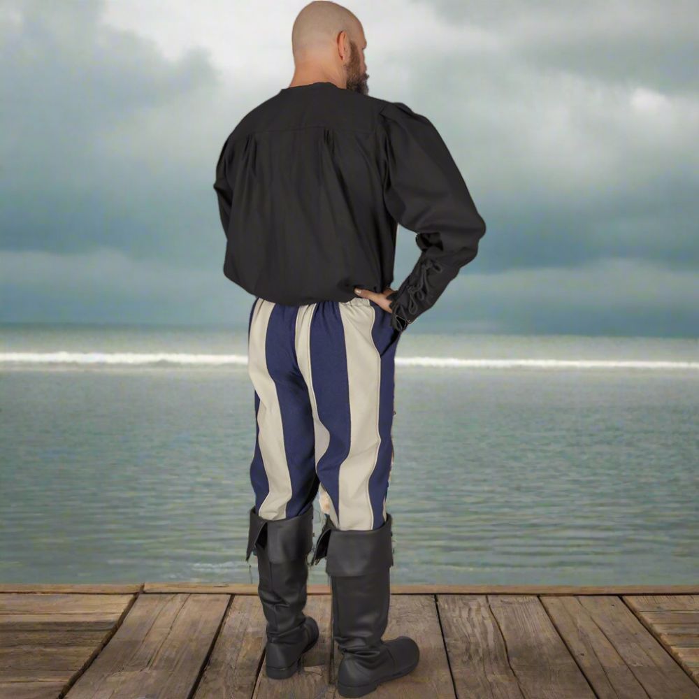 Man from behind wearing classic striped Pirate pants in navy and cream canvas, knee-length, with black boots.