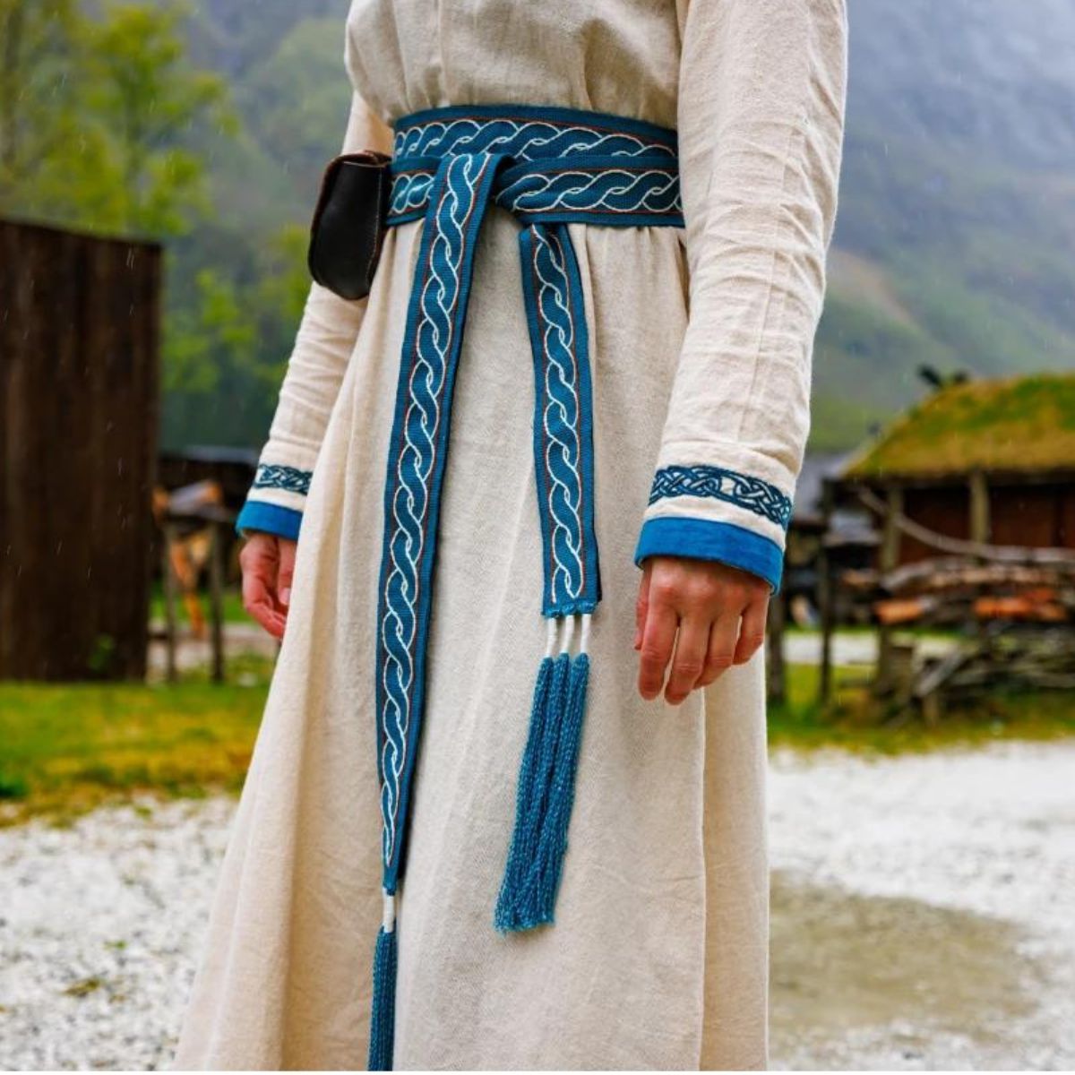 Blue and white braided cotton Pirate waist tie with tassels over a cream tunic.