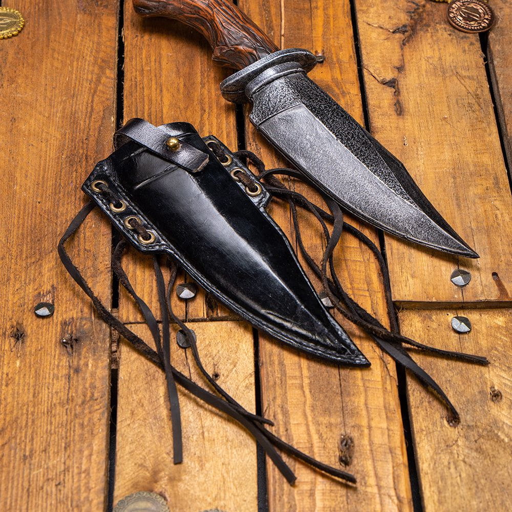 Black genuine leather Pirate knife scabbard with brass accents and straps, next to a silver LARP knife.