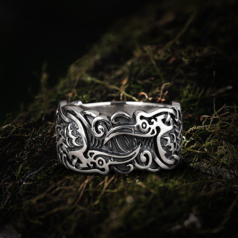 Sterling silver Pirate ring with detailed raven and scrollwork design on a mossy surface.