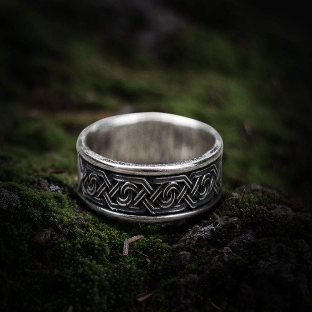 Sterling silver Pirate ring with a handcrafted ornamental pattern on a mossy surface.