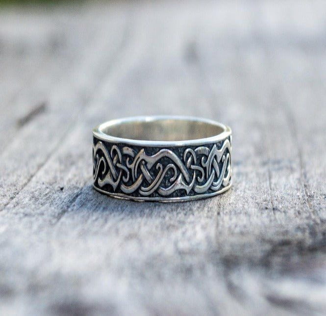 Handcrafted sterling silver Pirate ring with intricate ornamental patterns, resting on a wooden surface.