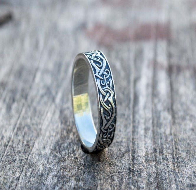 Handcrafted sterling silver Pirate ring with intricate Celtic knotwork design on a wooden surface.