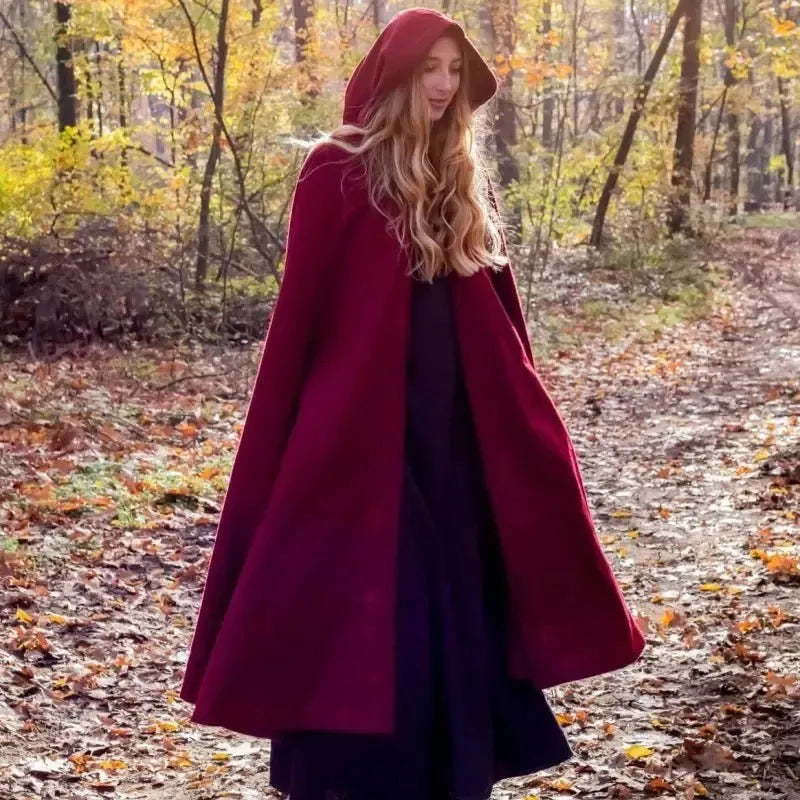 Long red hooded Pirate cloak made of heavy wool, worn by a woman in an autumn forest.