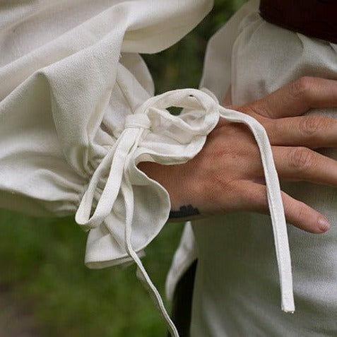 Close-up of a white, loose-fit Ladies' Pirate shirt with adjustable drawstring wrist cuff.