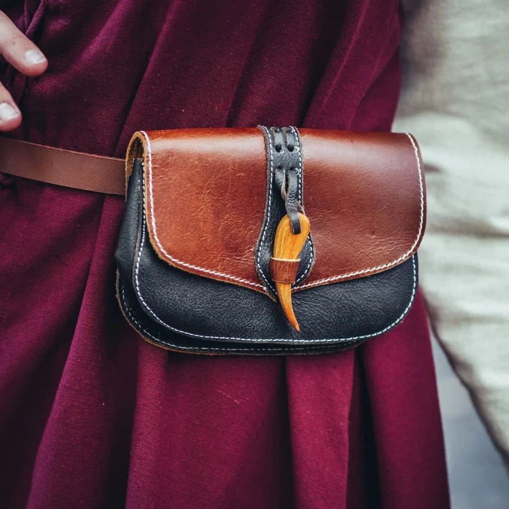 Two-tone brown and black leather Pirate belt pouch with a distinctive wooden clasp, worn on a maroon tunic.