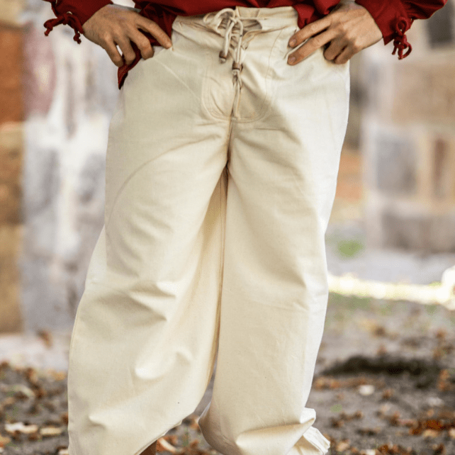 Loose-fit natural cotton Pirate pants with lace-up front closure and buttoned ankle cuffs.