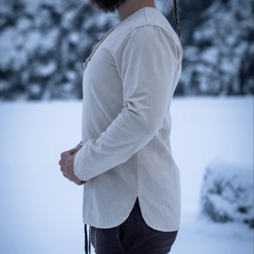 Natural cotton long-sleeve Pirate tunic with lace-up collar, shown on a person in a snowy setting.