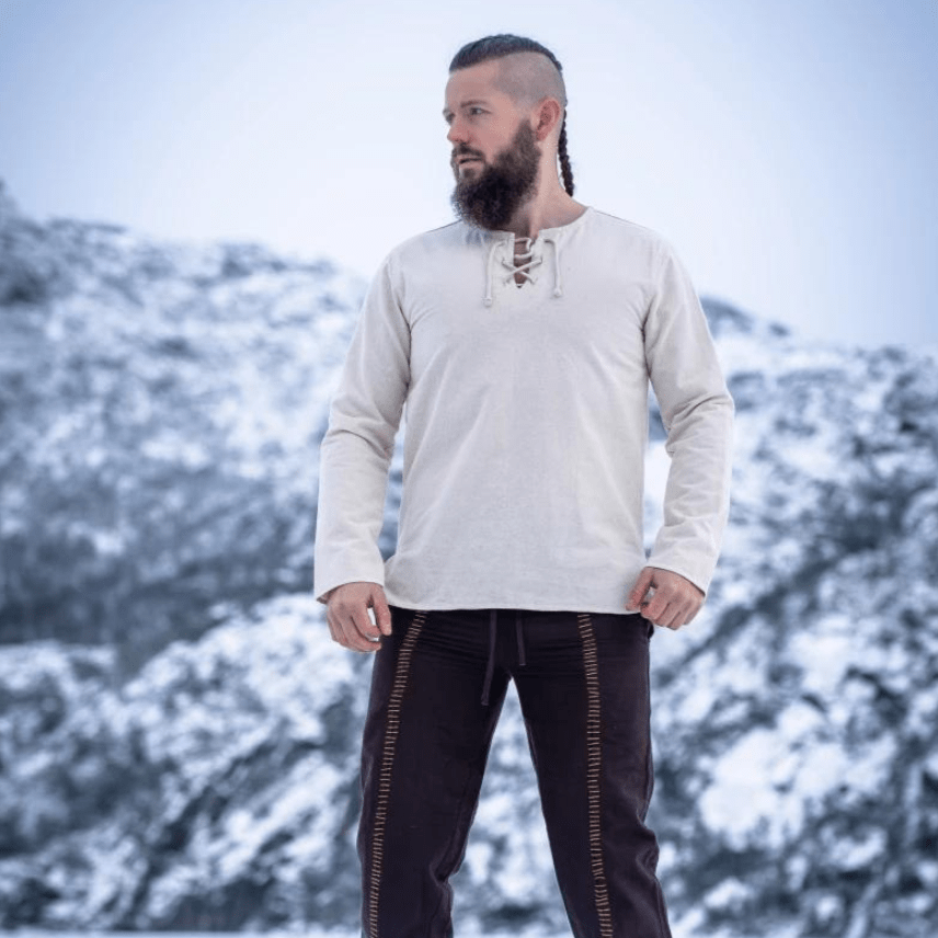 Natural cotton long-sleeve Pirate tunic with a lace-up collar, worn by a man against a snowy backdrop.