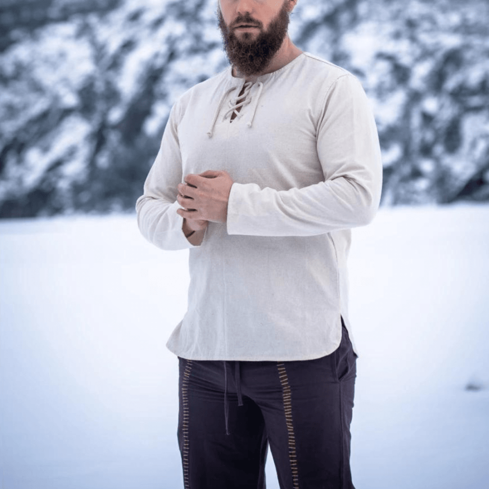 Natural cotton long-sleeve Pirate tunic with lace-up collar, worn by a bearded man in a snowy landscape.