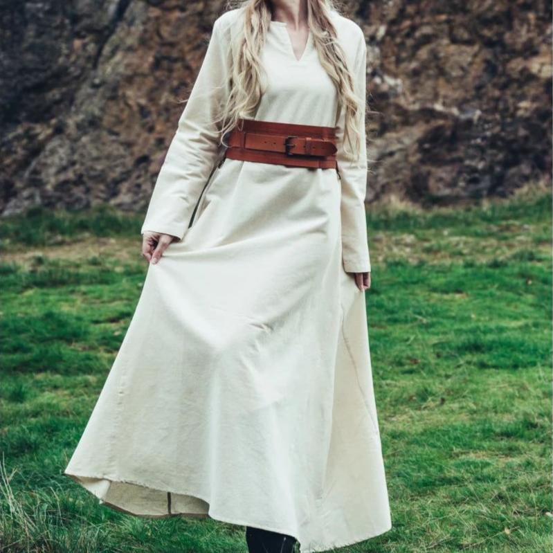 Natural cotton Pirate's underdress in cream, with a brown leather belt, worn by a woman outdoors.