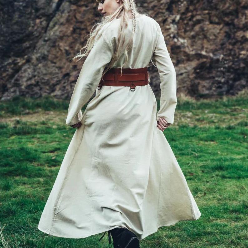 Natural cotton Pirate's underdress in cream, worn with a wide brown belt, flowing in a grassy field.