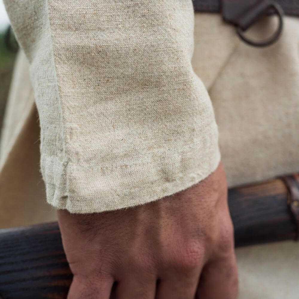 Natural linen Pirate tunic sleeve with classic cut and natural color, worn by a hand holding a prop.