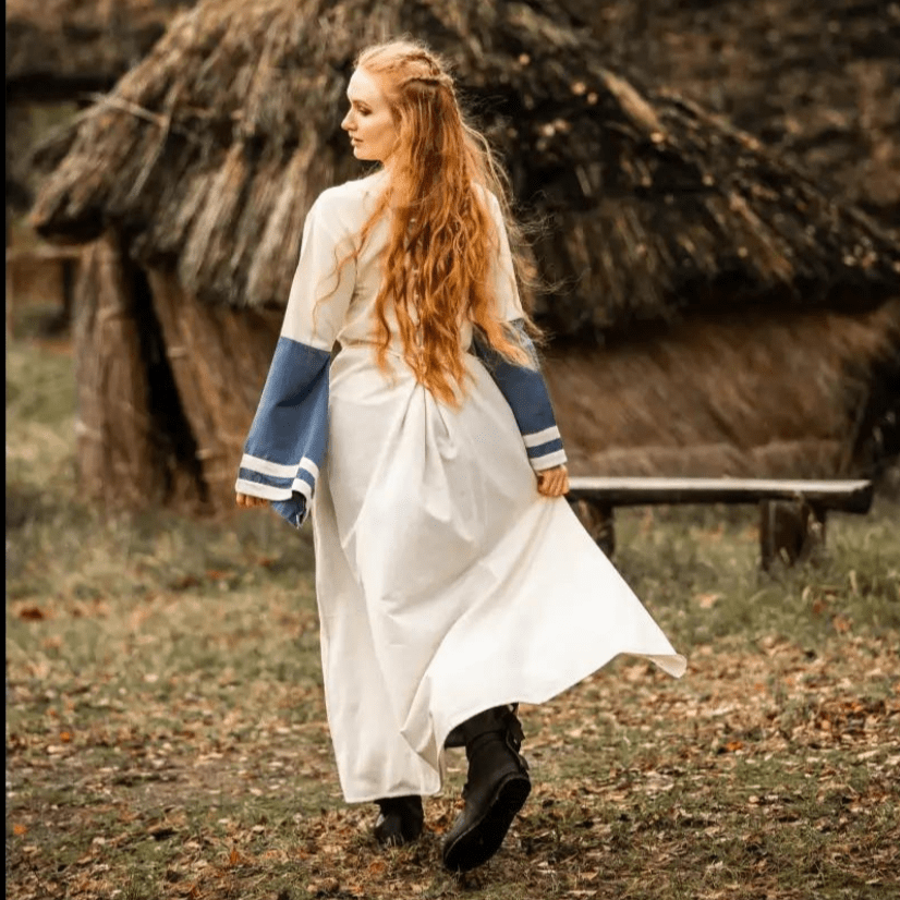 Natural and blue cotton Pirate dress with long sleeves and laced front, worn by a woman.