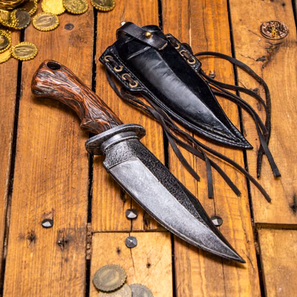 Pirate foam combat knife with faux wood handle and black leather scabbard on a wooden surface with coins.