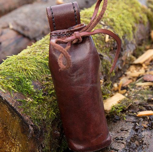 Brown genuine leather Pirate telescope pouch with belt loop and tie closure, resting on mossy wood.