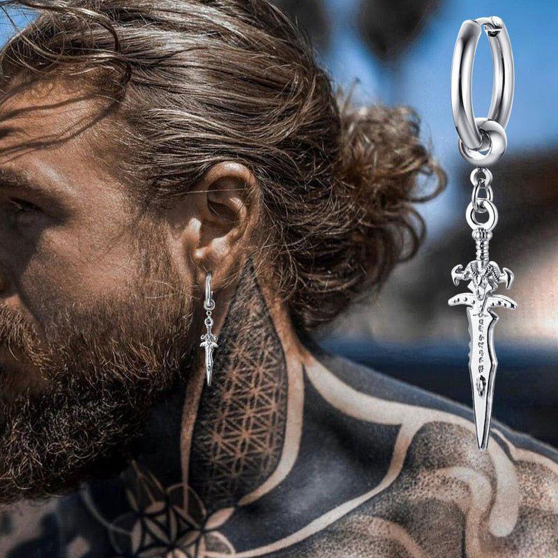 Stainless steel pirate dagger hoop earring on a man's ear, with a close-up of the silver pendant.