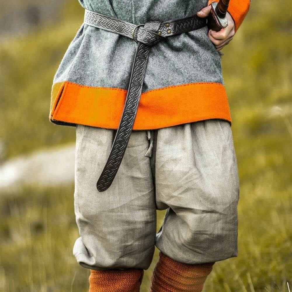 Stone grey linen Pirate pants with drawstring waist and tapered legs, worn with a grey tunic and belt.
