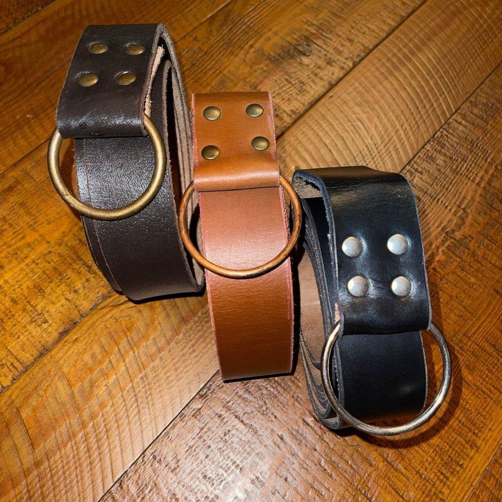 Three full grain leather Pirate belts: dark brown with brass ring, light brown with brass ring, and black with silver ring.