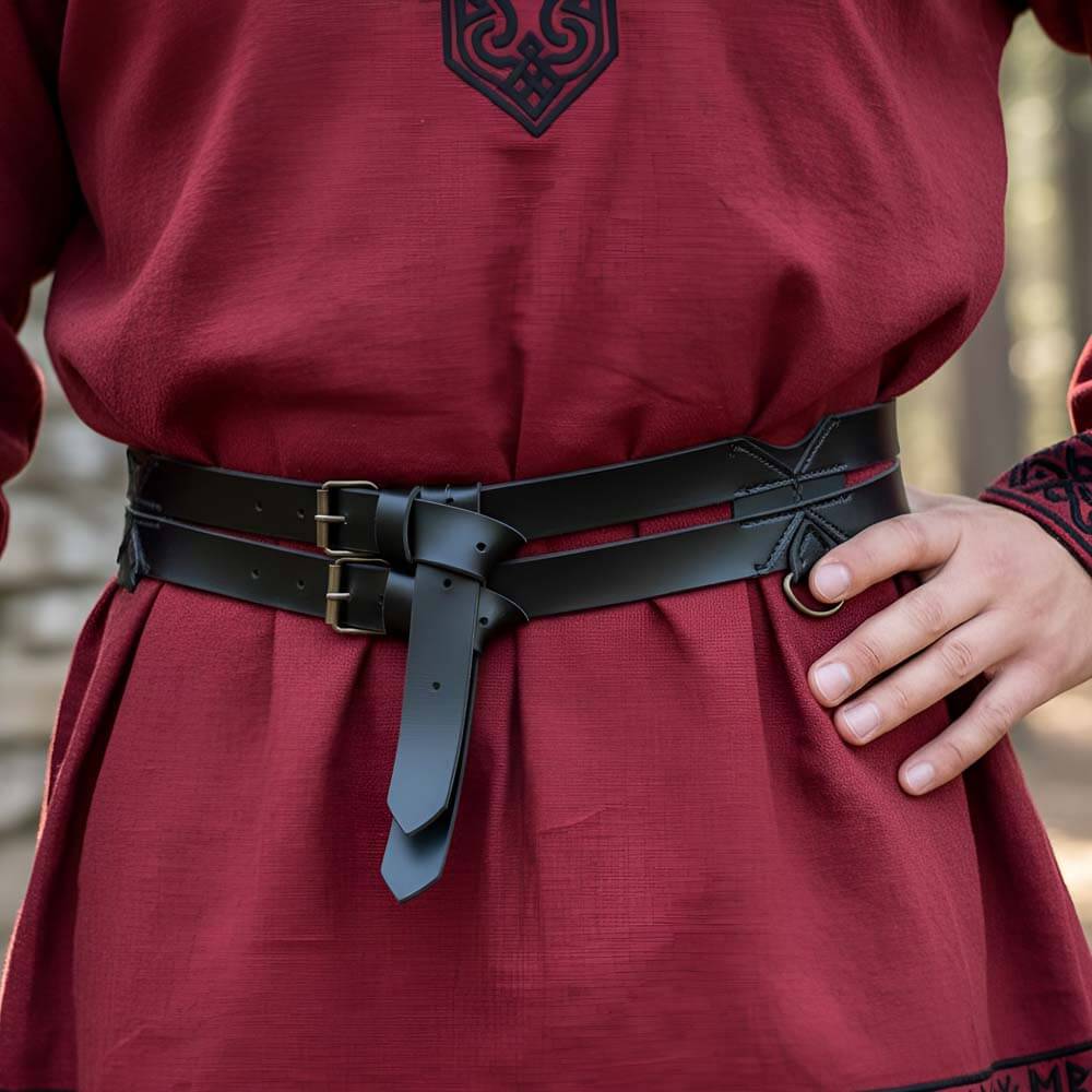 Black faux leather Pirate twin belt with brass D-rings, worn over a red tunic.